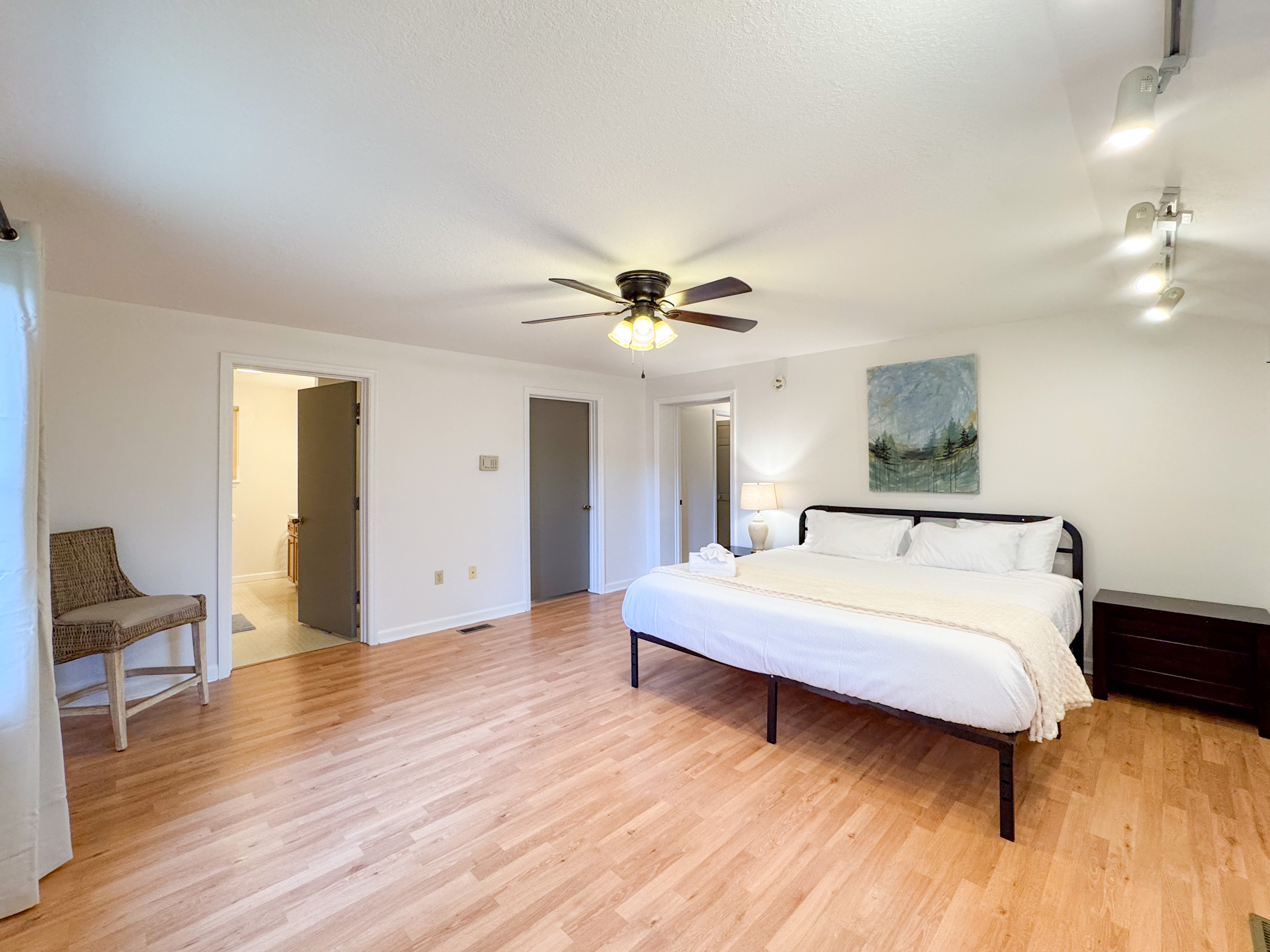The master bedroom features a king size bed, large space, closet, and ensuite bathroom with accessibility features. 