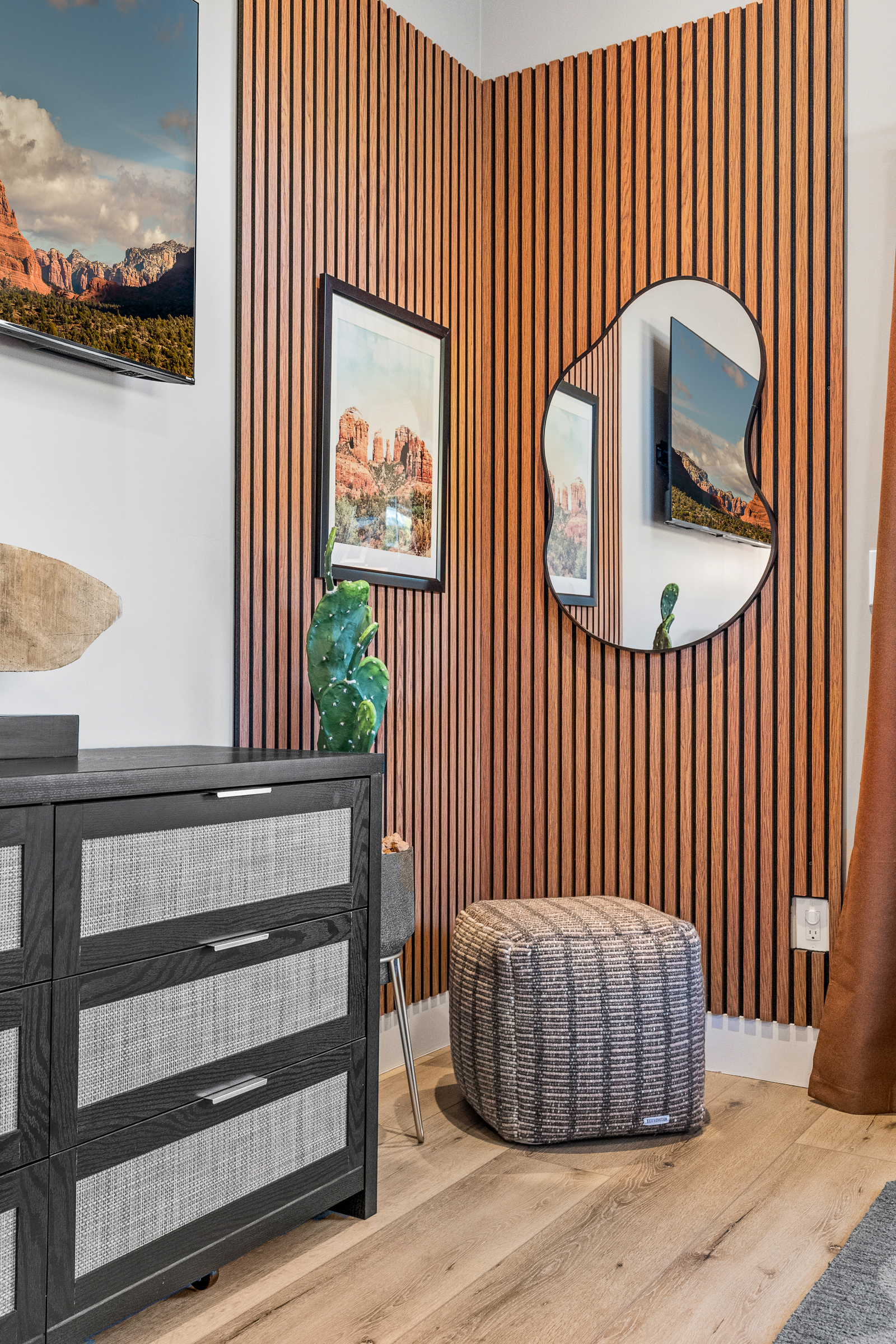Warm wood textures, local artwork, and curated accents add character and a calm, grounded feel to the bedroom.