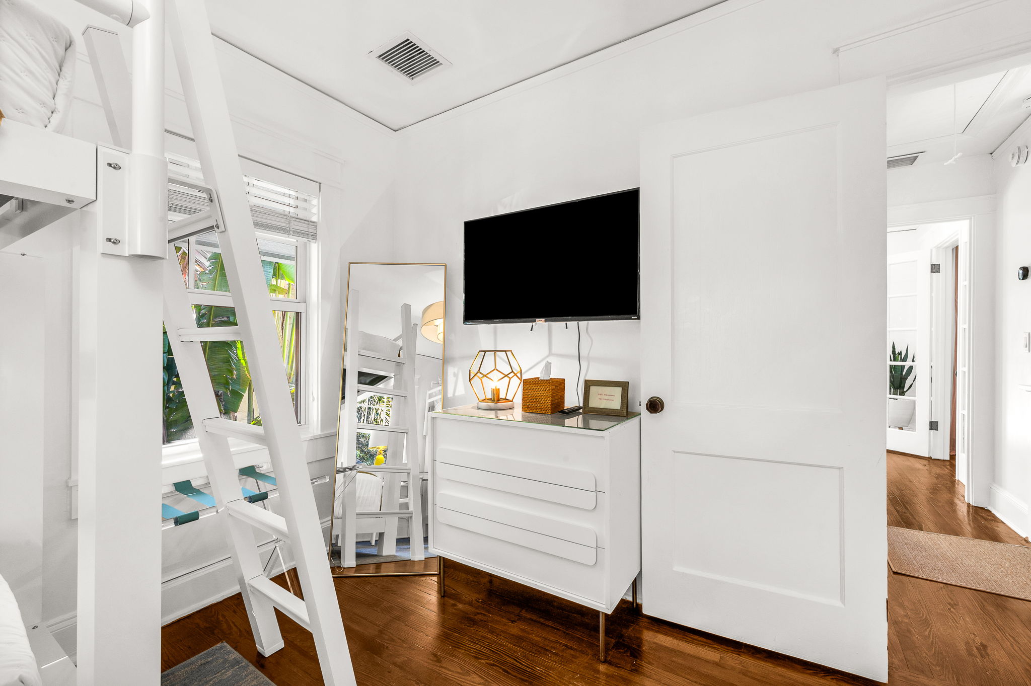 Bright and airy bunk bed bedroom featuring two new durable twin XL bunk beds, modern artwork, and a personal desk and chair—ideal for remote work. Enjoy a smart TV and peaceful views overlooking the quiet Flamingo Park street.