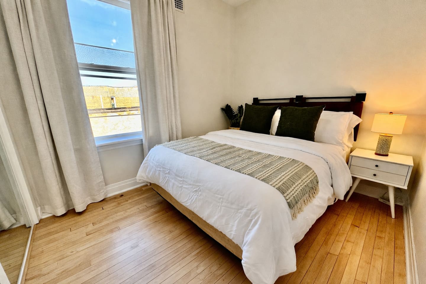 Bright bedroom with comfortable bed and natural sunlight.