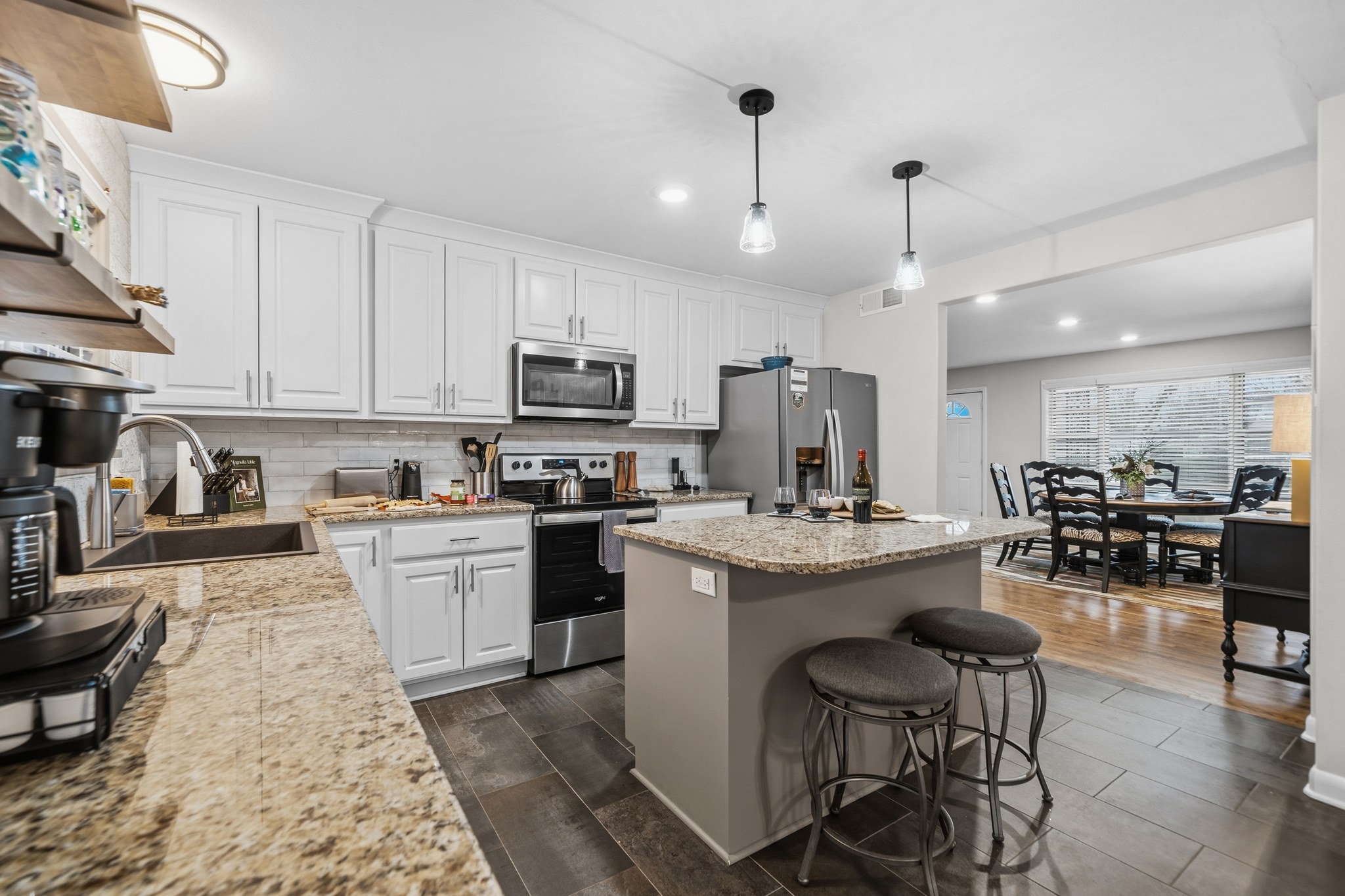 Spread out across the counters — plenty of granite, plenty of cabinets, and the table waiting just beyond.