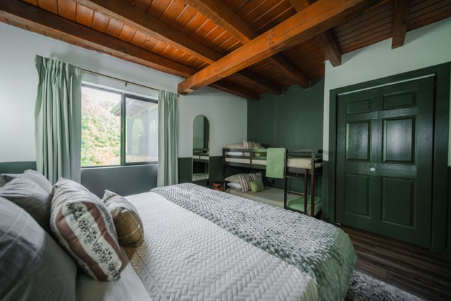 A bedroom featuring a king bed and twin-over-twin bunk bed, offering a comfortable setup for families.
