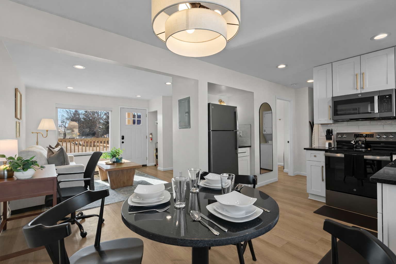 Open-concept living and dining area with modern kitchen, stylish lighting, and cozy seating—bright, spacious, and designed for comfort and connection.