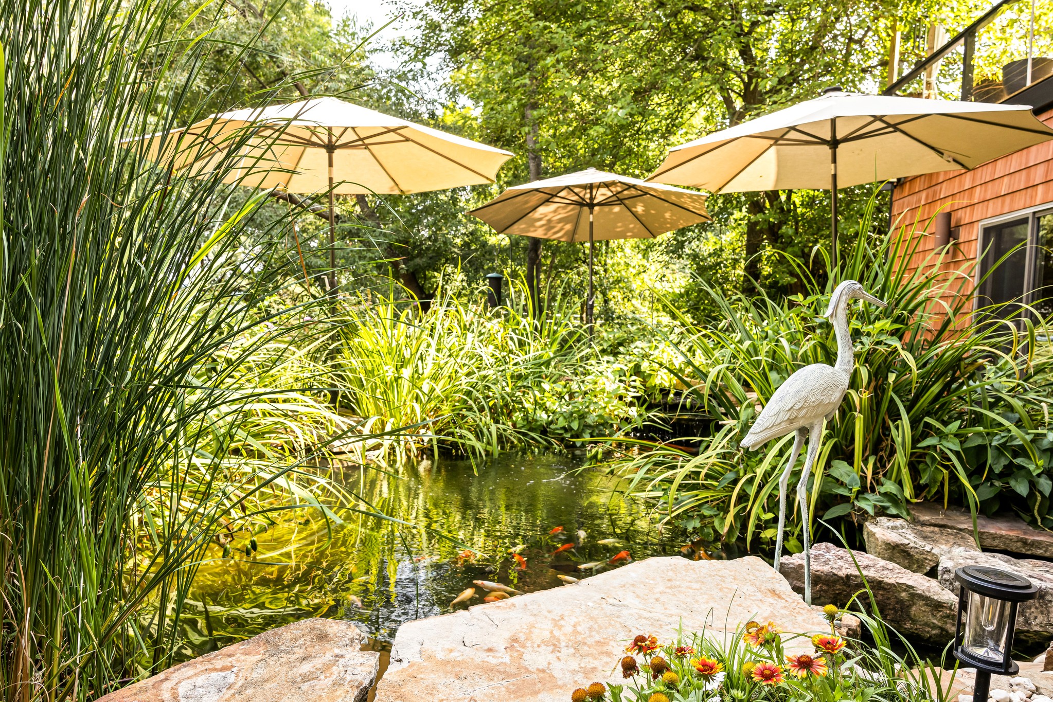 Meet Henrietta Heron, the garden statue guarding our signature 7,000-gallon Koi pond! Grab morning coffee, feed the fish, and experience why Hilltop Oasis Abingdon is truly a world away.