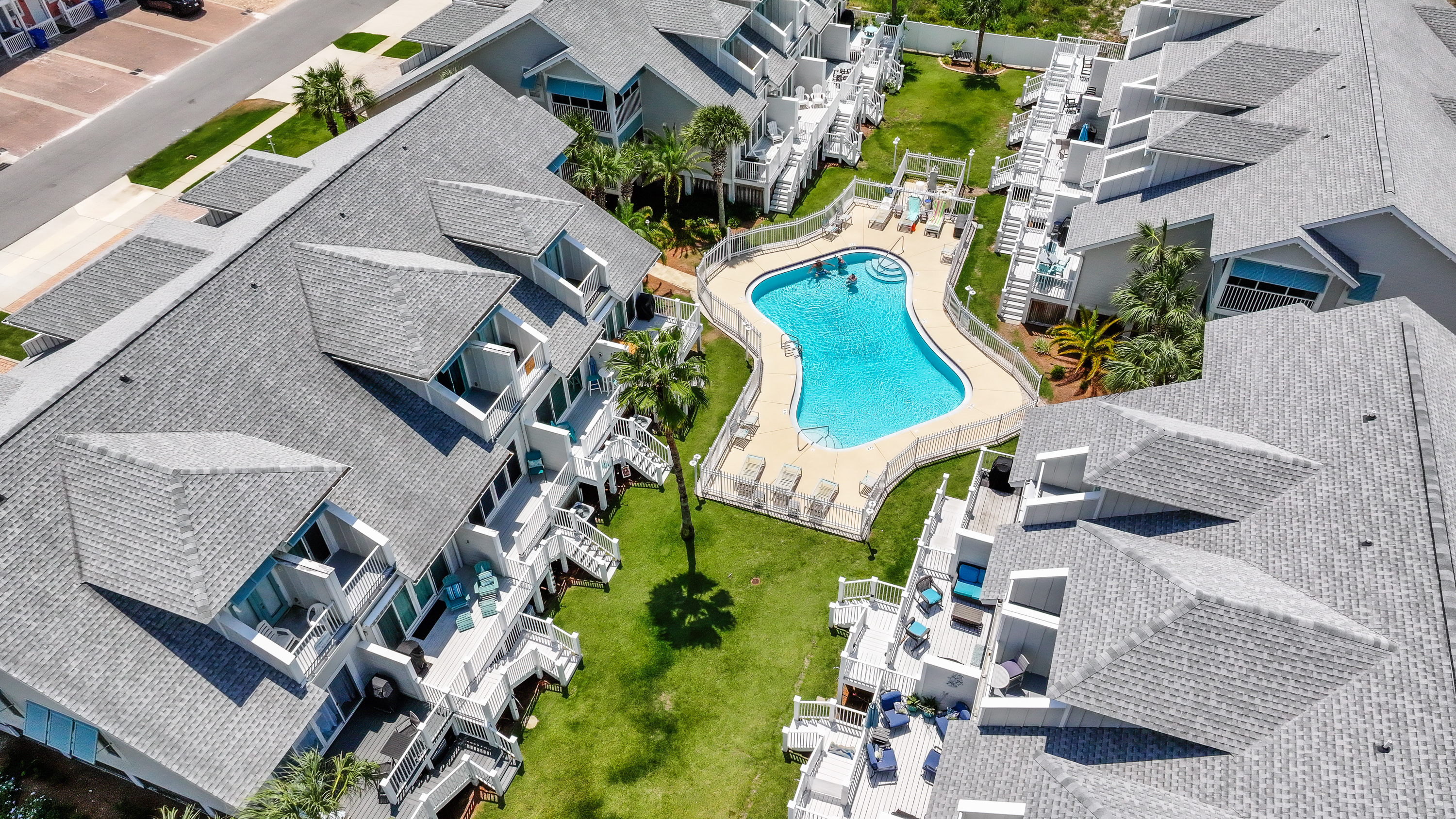 Beautiful aerial view showcasing the resort-style pool, landscaped grounds, and convenient location near the beach