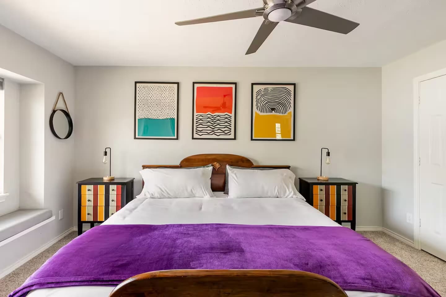 Spacious bedroom with king bed and vibrant wall art.