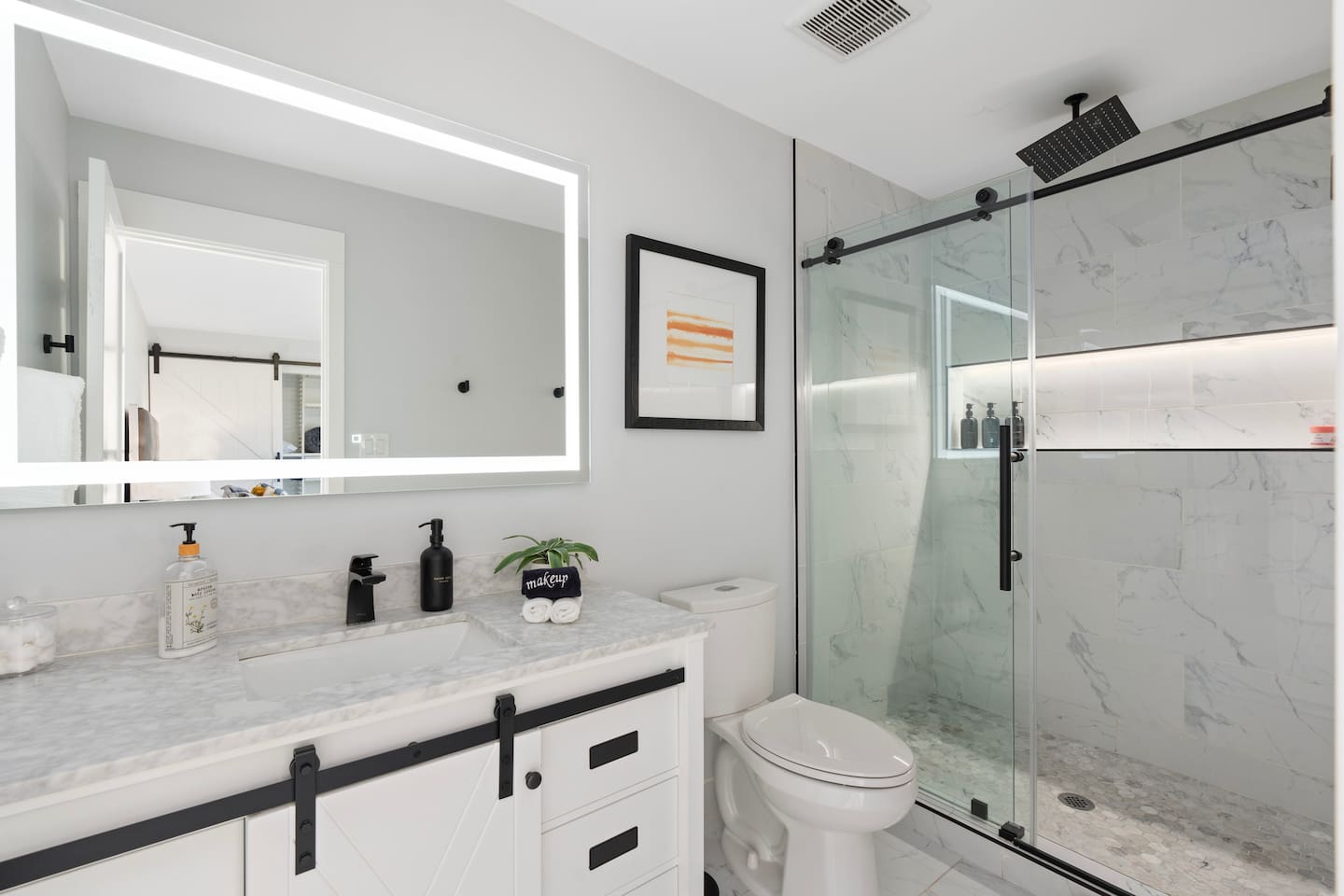 Bright and modern bathroom featuring a glass-enclosed shower, minimalist decor, and clean lines throughout.

