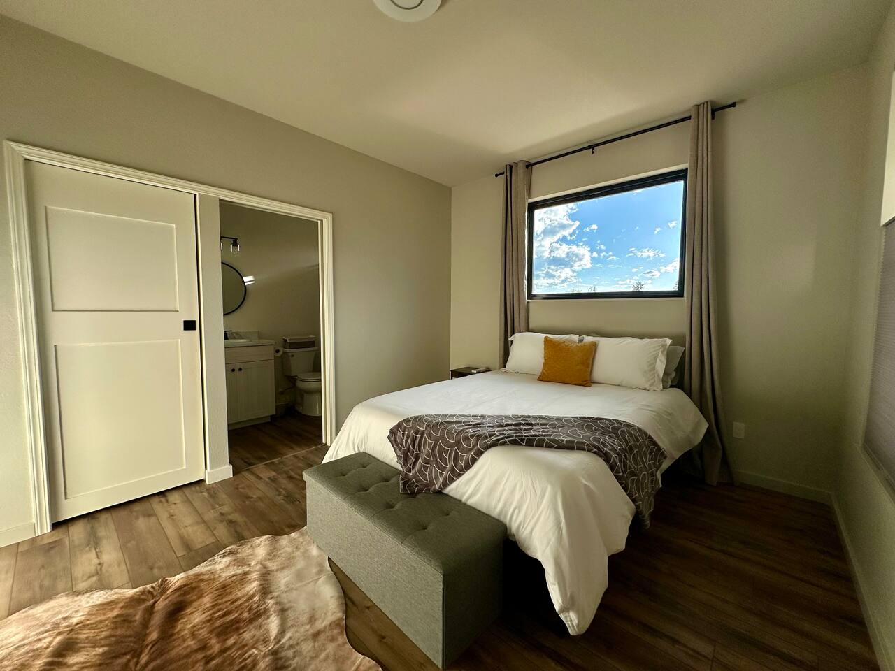 Sleep well one of the two spacious bedrooms.  Each had a walk-in closet, queen bed, luxury linens, full length mirror, own mini-split and bathroom.   The gorgeous picture windows have blackout curtains for night.  This room has a storage bench.  