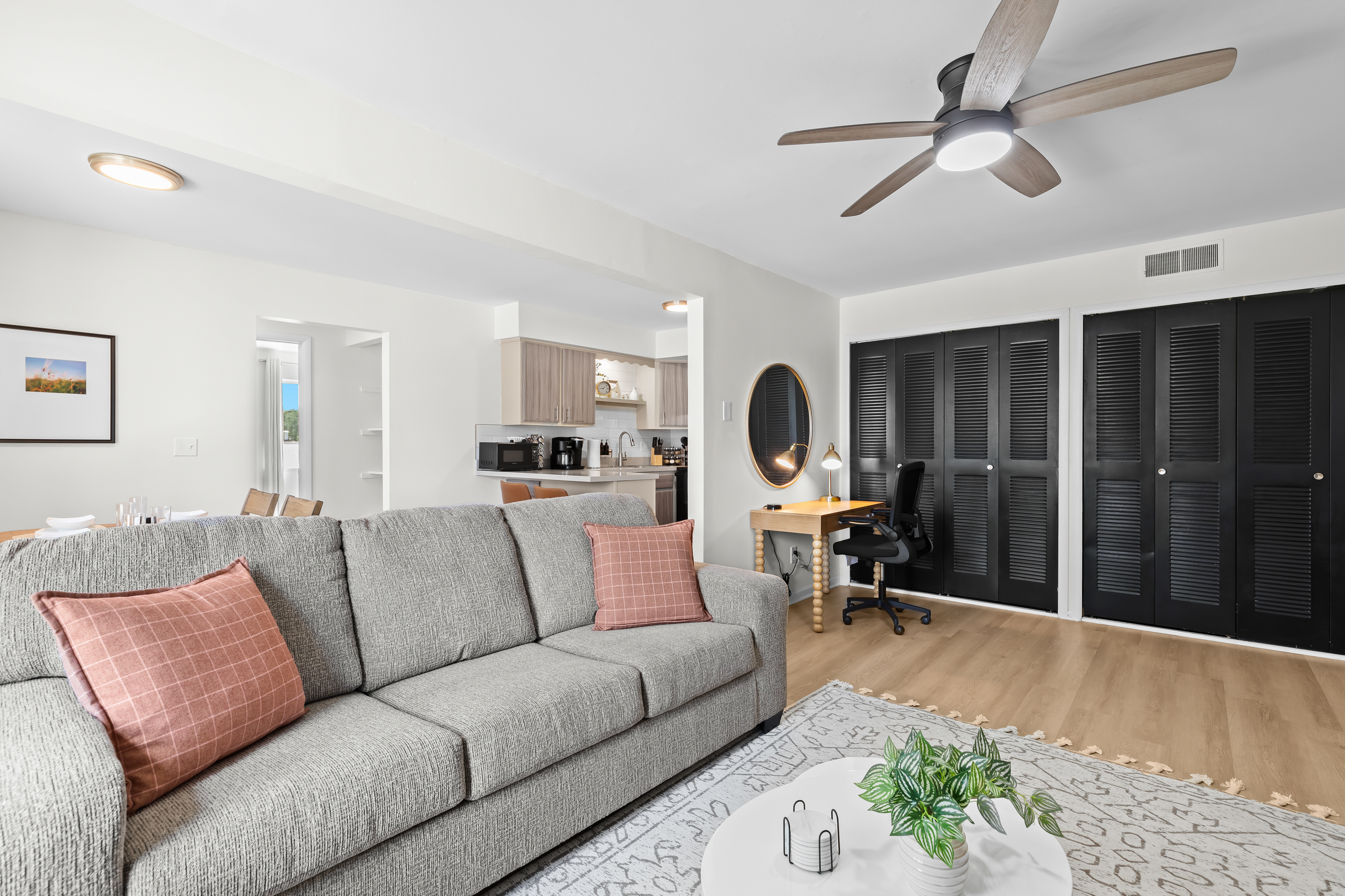 Open-concept living area with plush seating, work desk, and natural light.