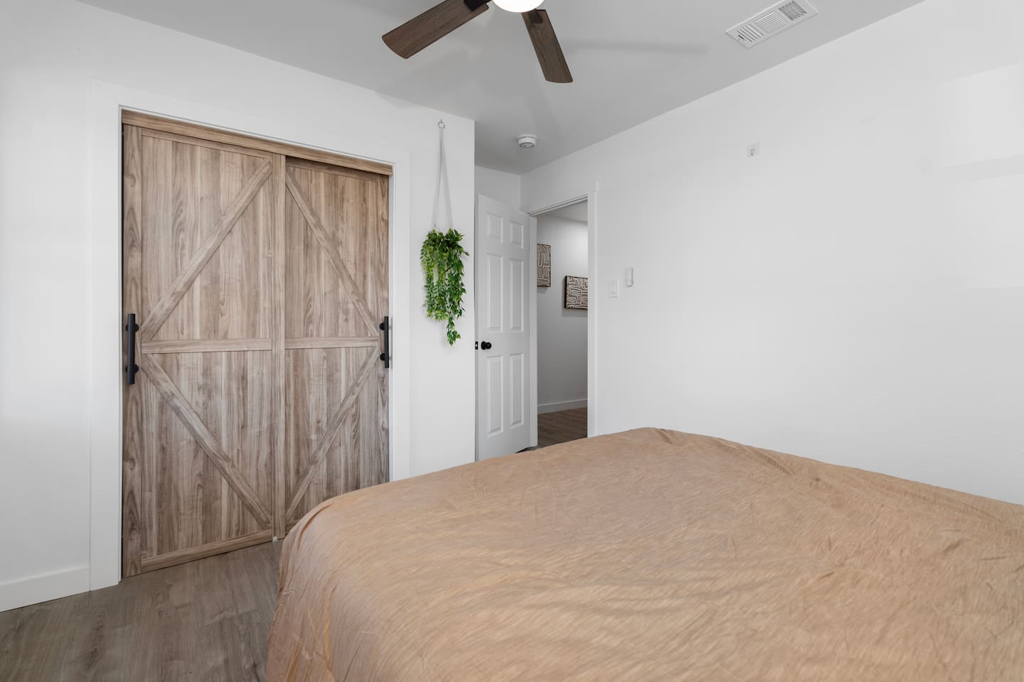 Comfortable queen bedroom with soft bedding, ceiling fan, and ample closet space. Includes fresh linens, extra blankets, and hangers for easy organization.