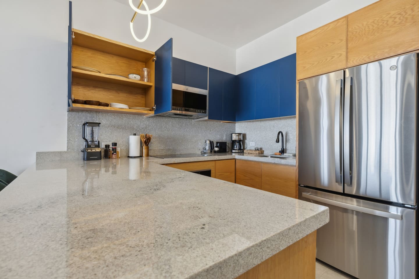 Discover a complete set of plates, cups, and glasses neatly stored in the cabinets, ready for your dining needs.
