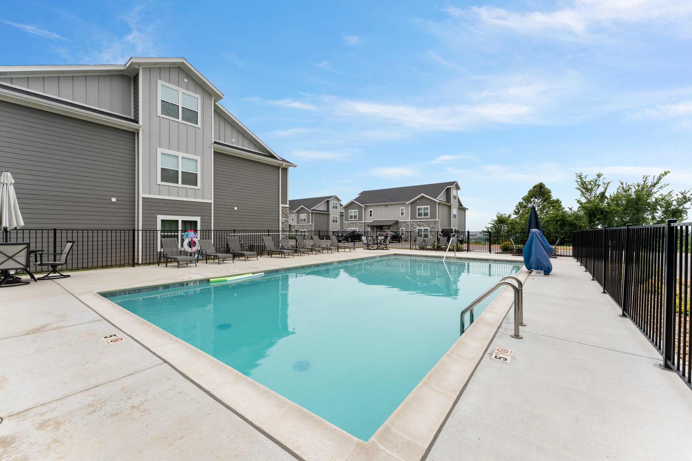 Shared community pool with lounge chairs along the iron railing. It's just outside the building, so a swim is an easy decision.