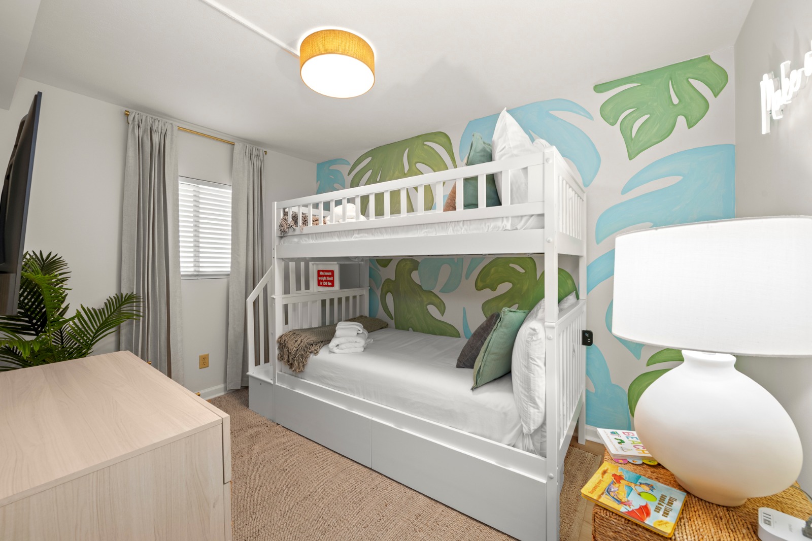 Let the kids stretch out in their own tropical hideaway, where playful palm murals and cozy bunks make bedtime feel like part of the vacation.