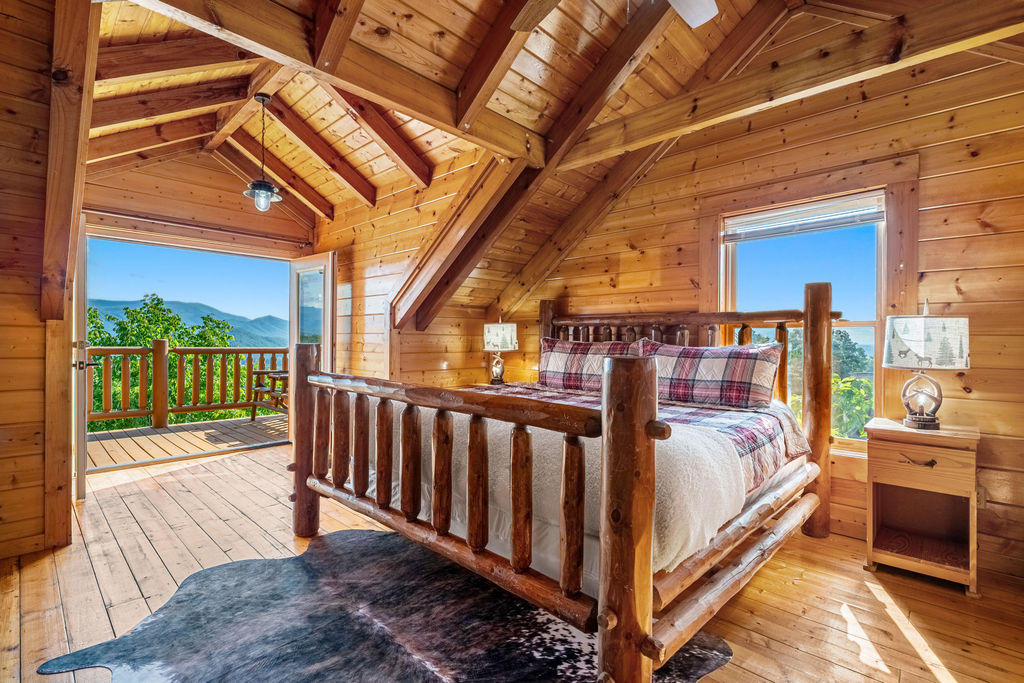 This cozy retreat features a king bed, flat-screen TV, private ensuite with a shower/tub combo, and direct access to a deck with stunning Smoky Mountain views.