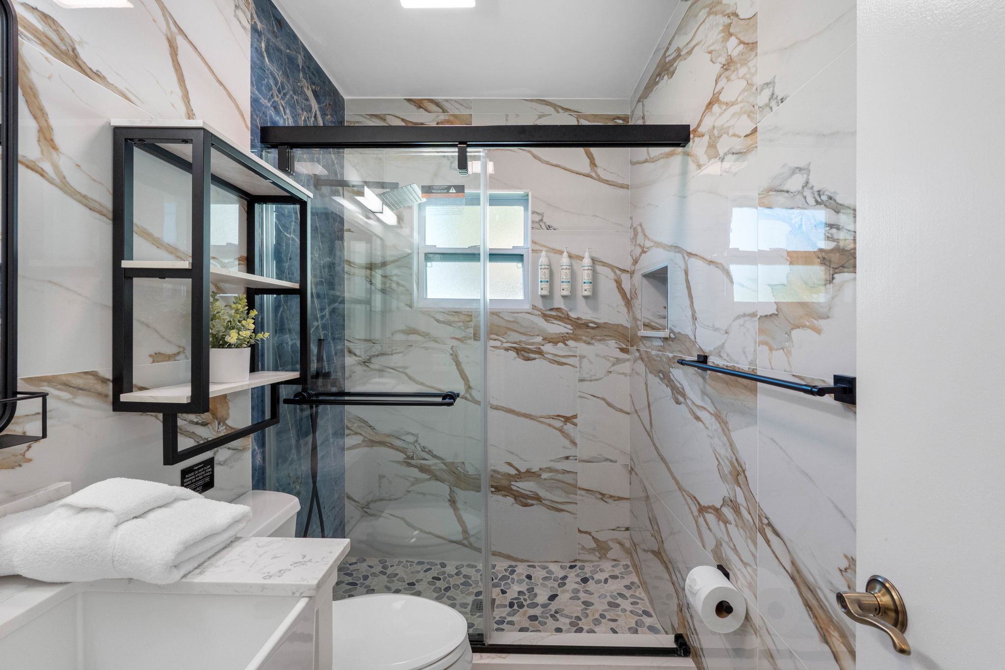 Soft tones, updated lighting, and a touch of greenery make this bathroom feel fresh and inviting.