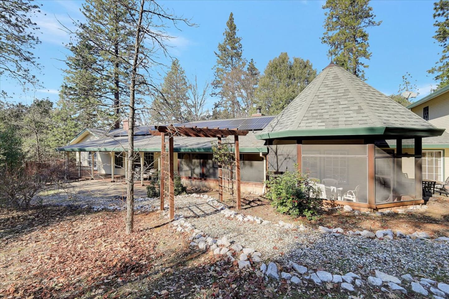 Wooded outdoor space with a gravel path, fire pit seating, and room to enjoy the trees.
