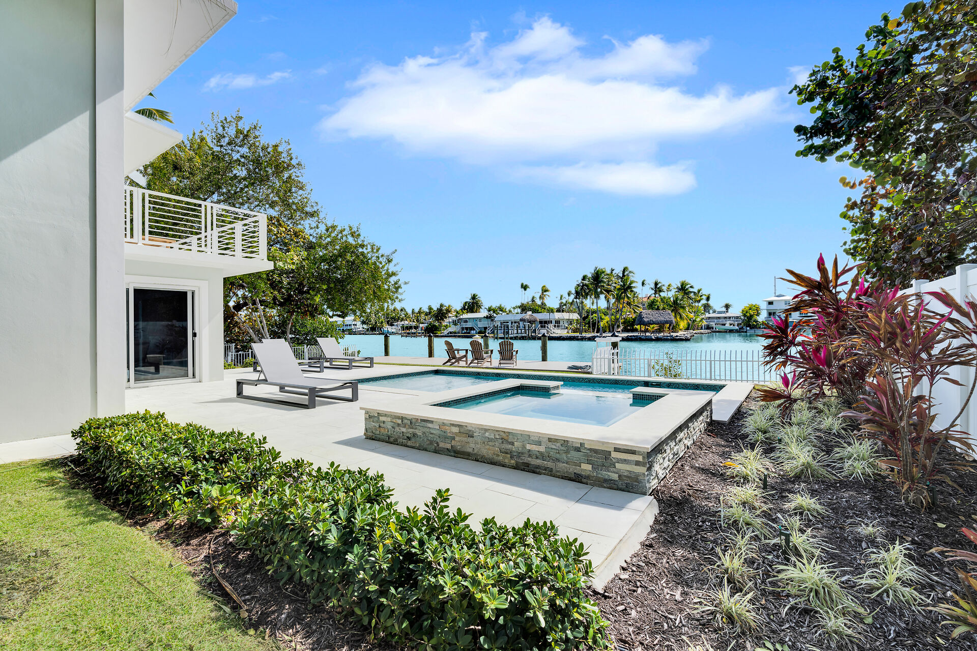 Pool and hot tub among natural landscaping.
