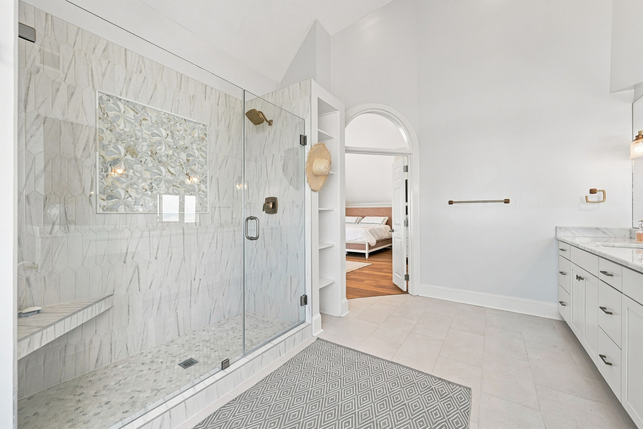 Every detail was thoughtfully designed in this modern ensuite bathroom, featuring a spacious walk-in shower, double vanity, and sophisticated gold fixtures.