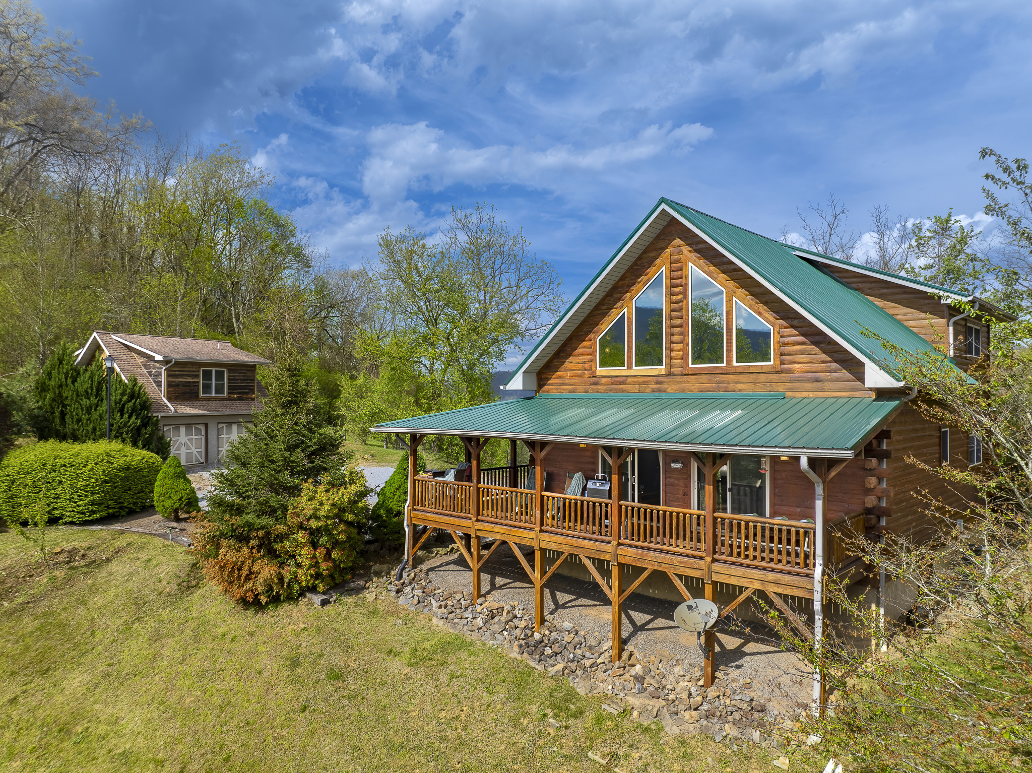 Exterior Retreat: Relax on the spacious porch, surrounded by lush greenery and mountain views!


