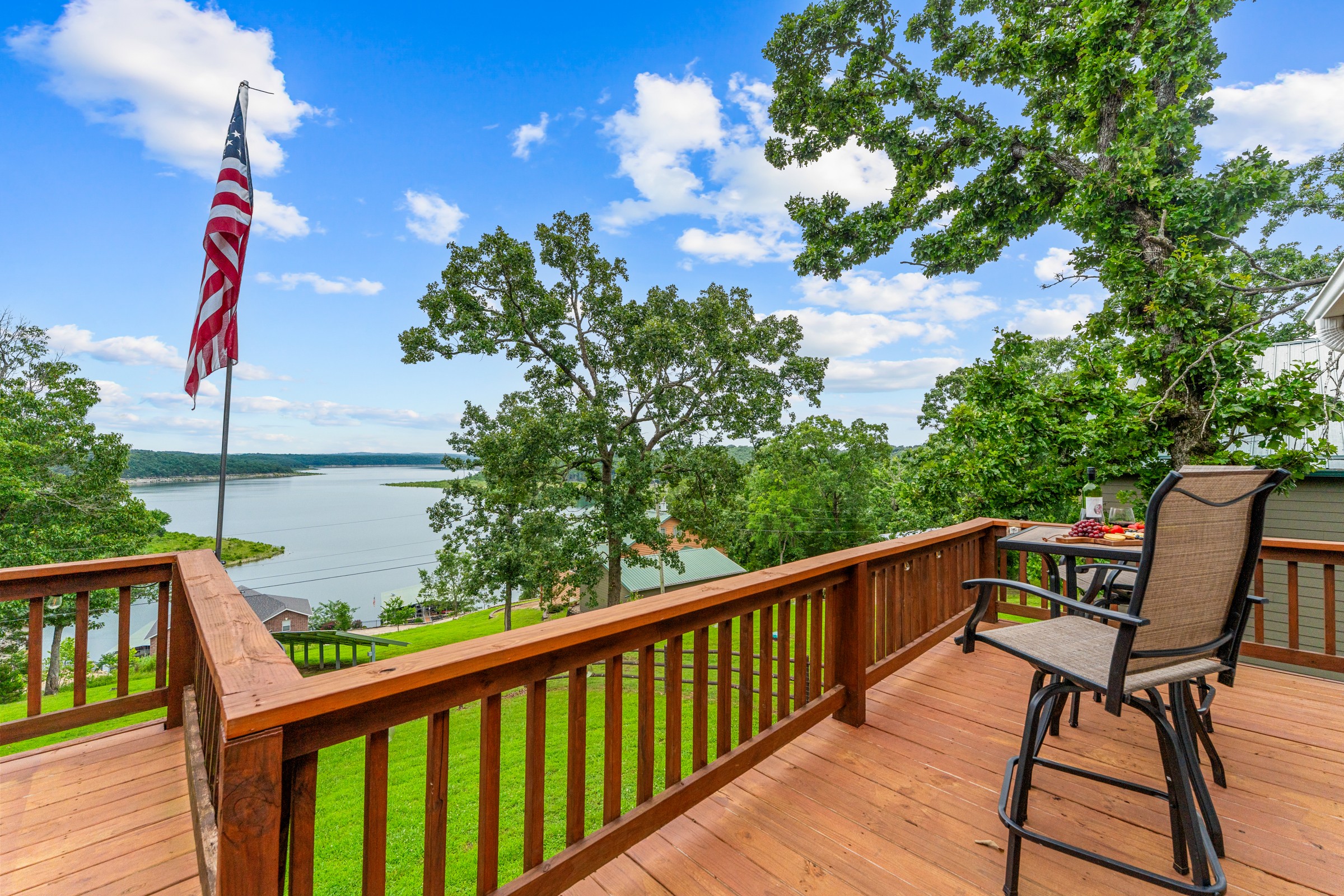 Upper deck with bar chairs, a flag and a wide lake view. Grab a drink and watch the water from up high.