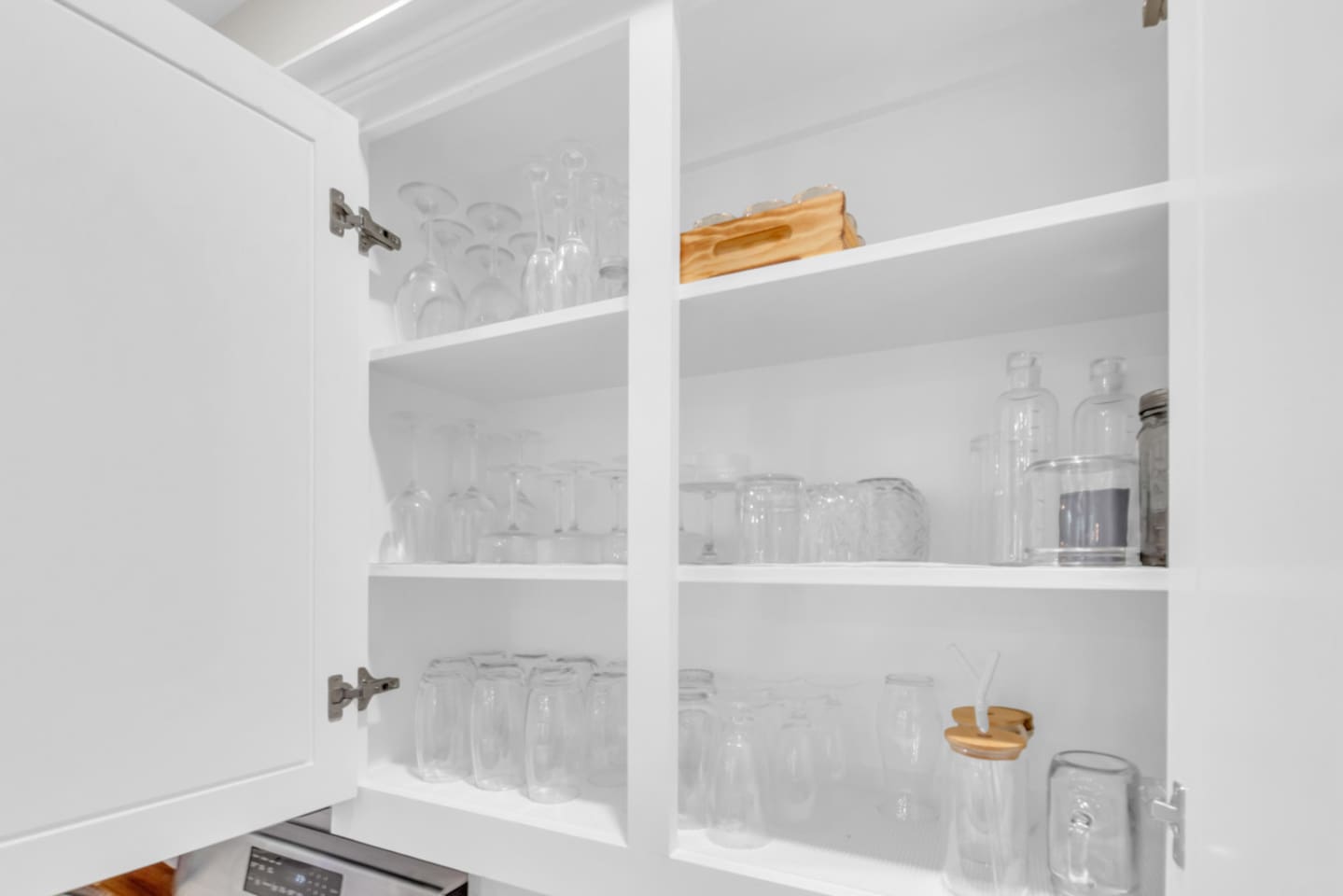 Kitchen cabinet stocked with elegant glassware including wine glasses