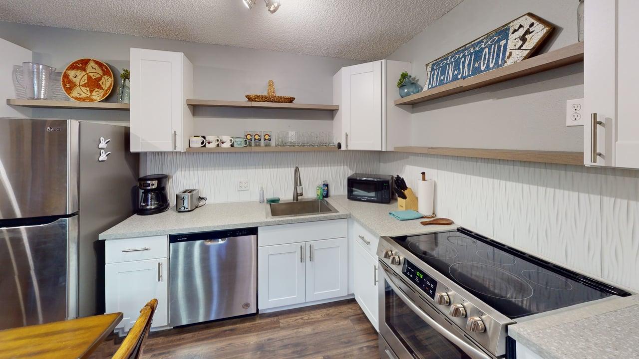 This image showcases a well-equipped kitchen, offering a comfortable and practical space for meal preparation. It's stocked with essential appliances and amenities.