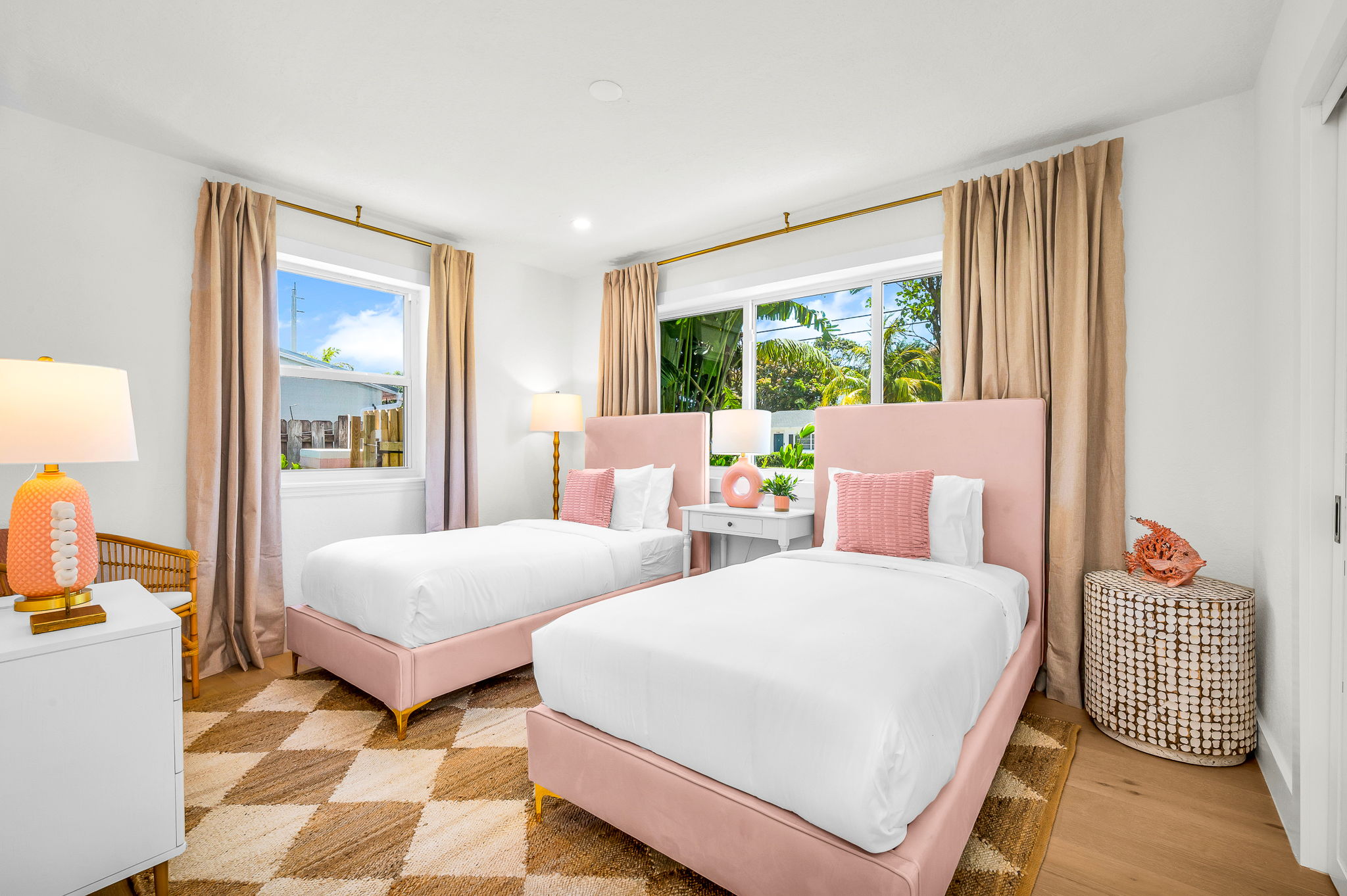 Chic and serene, this beautifully designed twin bedroom features plush velvet headboards, designer lighting, and abundant natural light with views of the lush tropical landscape—perfect for children or additional guests to unwind in refined comfort.