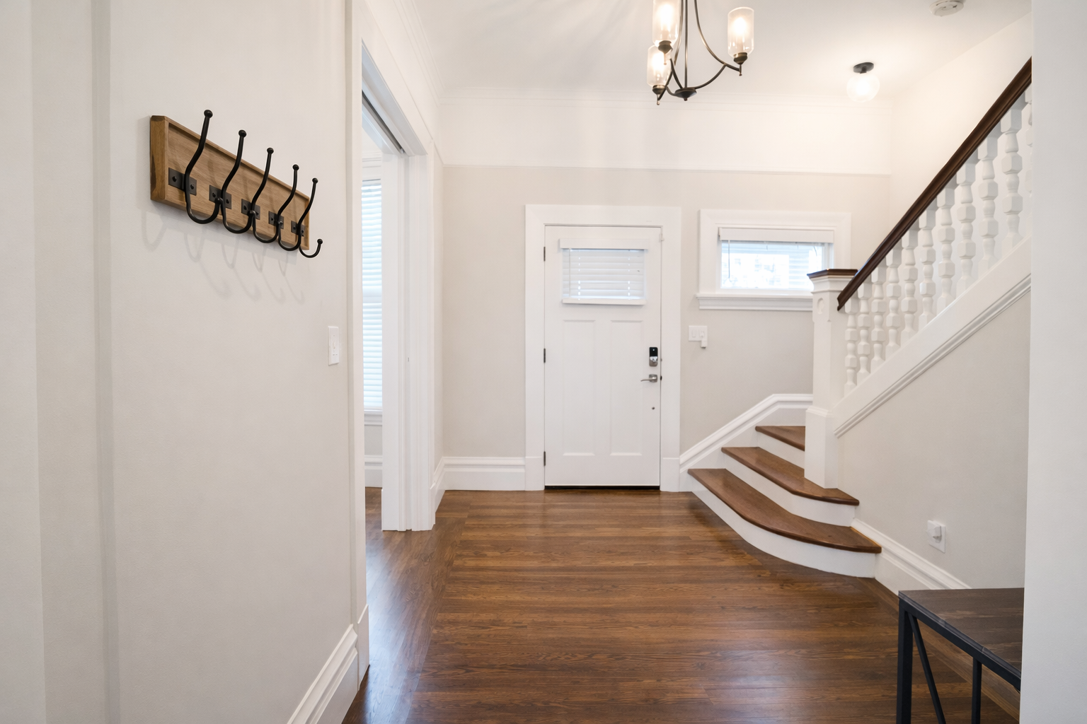 Step into a bright and airy foyer featuring original hardwood floors and a warm, inviting atmosphere.