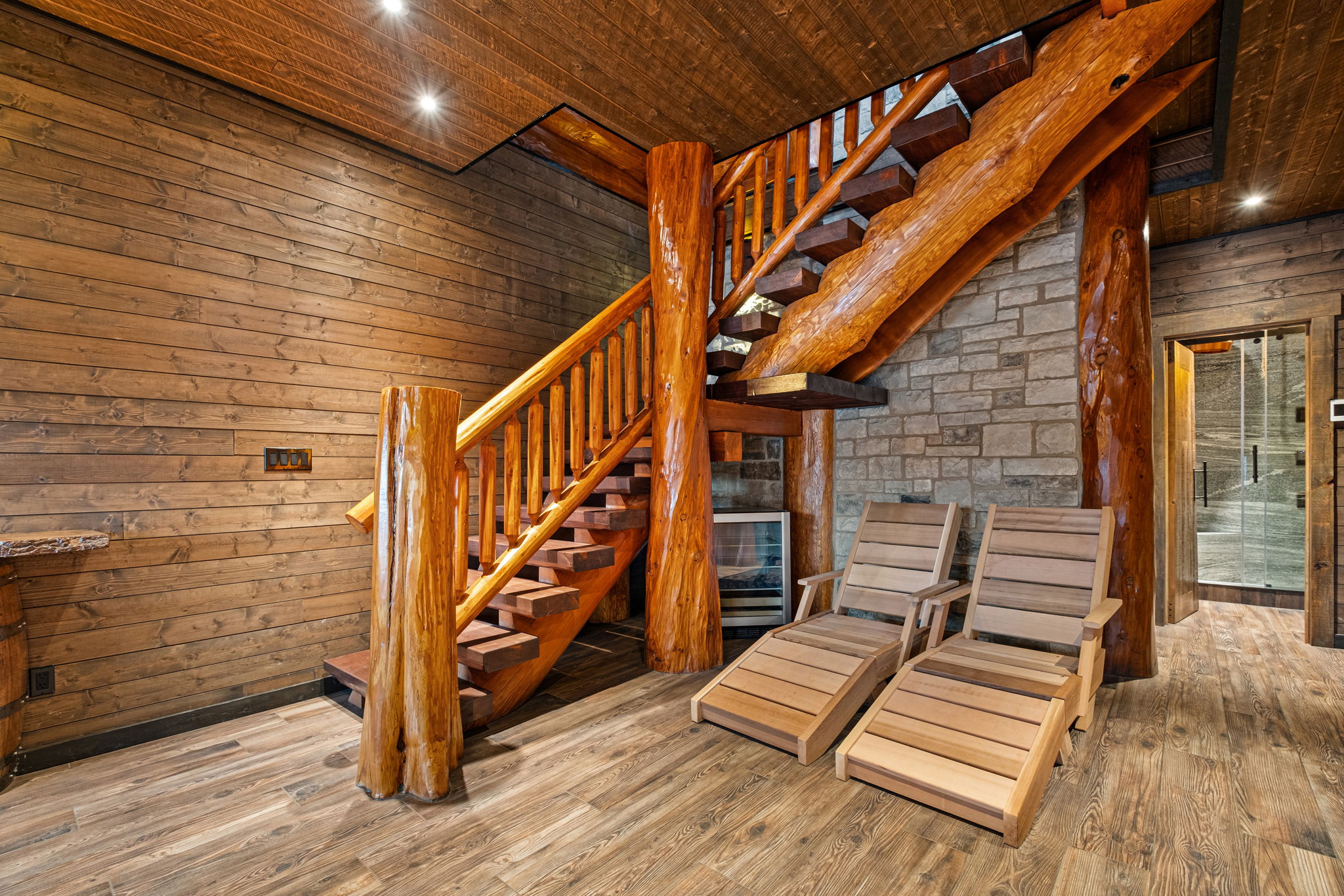 Lower-level relaxation zone with custom reclining loungers — perfect for cooling down after the sauna or enjoying peaceful lake views.