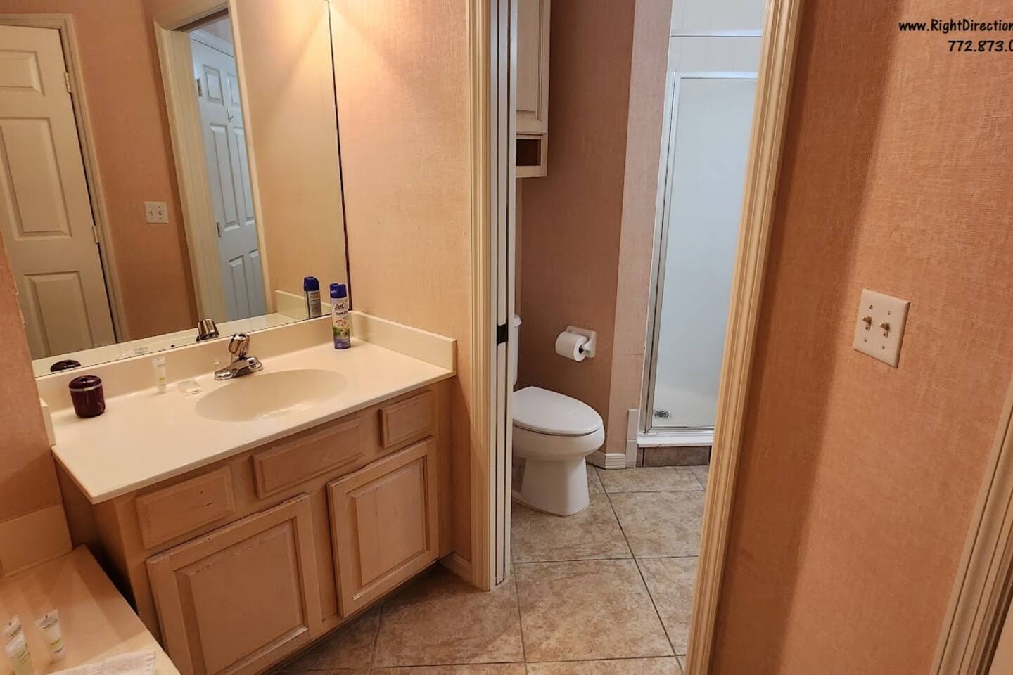 Bathroom with vanity storage, tile flooring, and convenient access to the shower area.