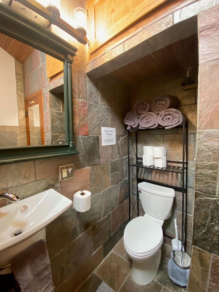 Main bathroom with floor to ceiling slate tile.