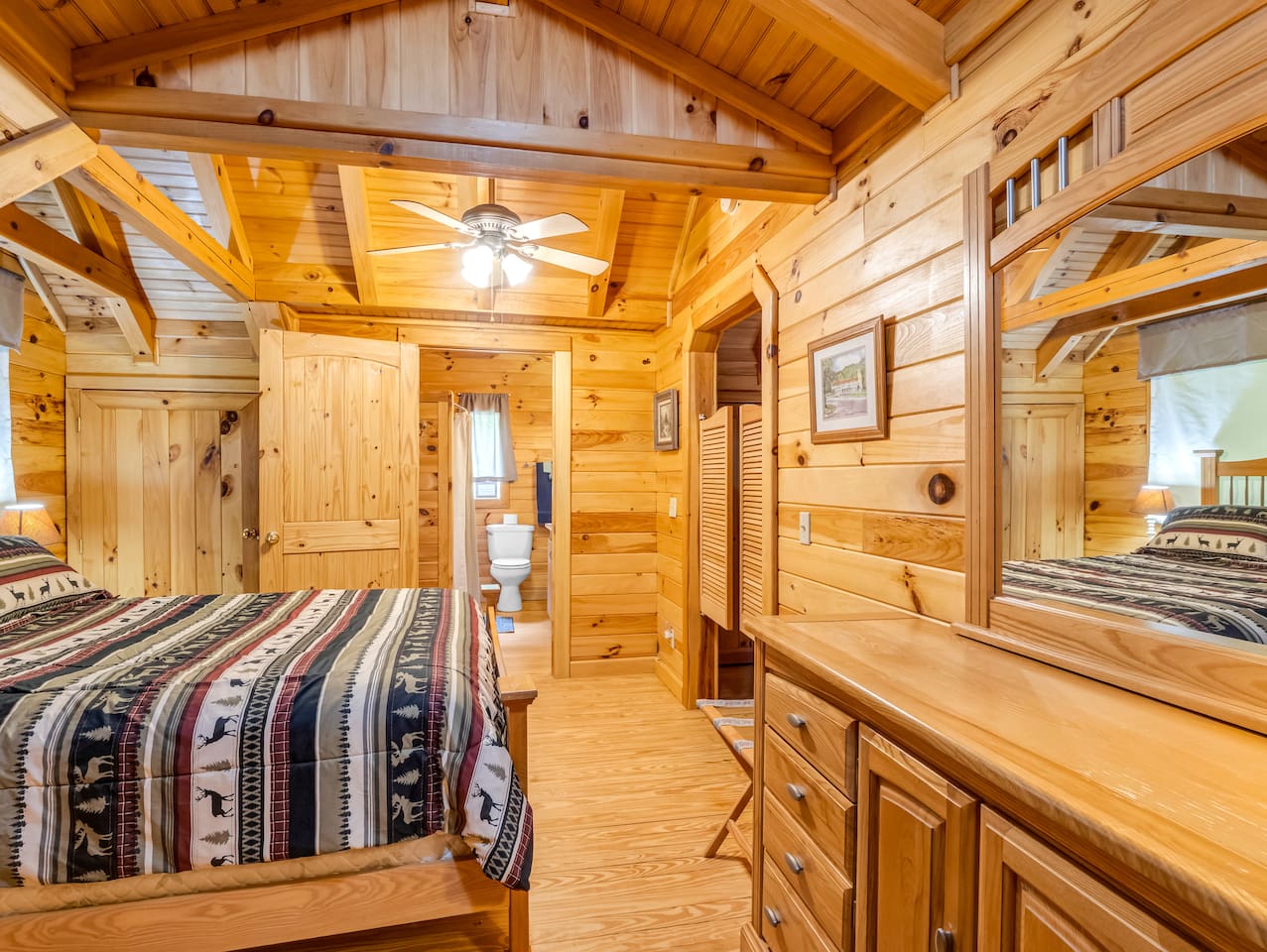 Third-level bedroom featuring a comfortable double bed, private bathroom, saloon doors, and plenty of storage space