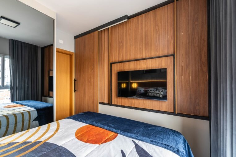 TV embutida no quarto com marcenaria planejada Desfrute de entretenimento no quarto com TV embutida, iluminação indireta e cortinas blackout para total conforto.