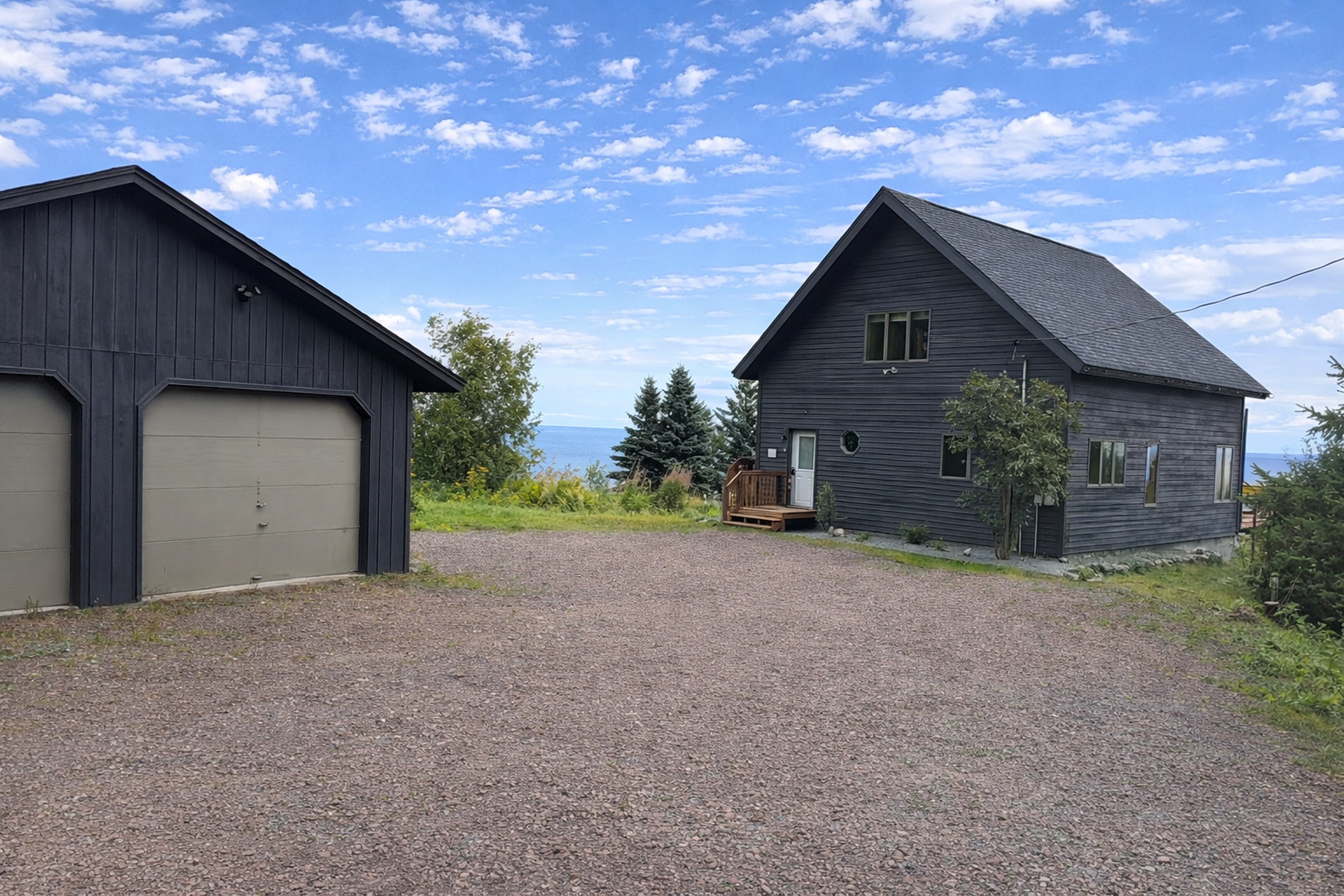 As you pull into the driveway, the garage and cabin come into view, with gentle glimpses of the scenery beyond. It’s a welcoming first impression, simple, inviting, and setting the tone for a relaxing North Shore getaway the moment you arrive.