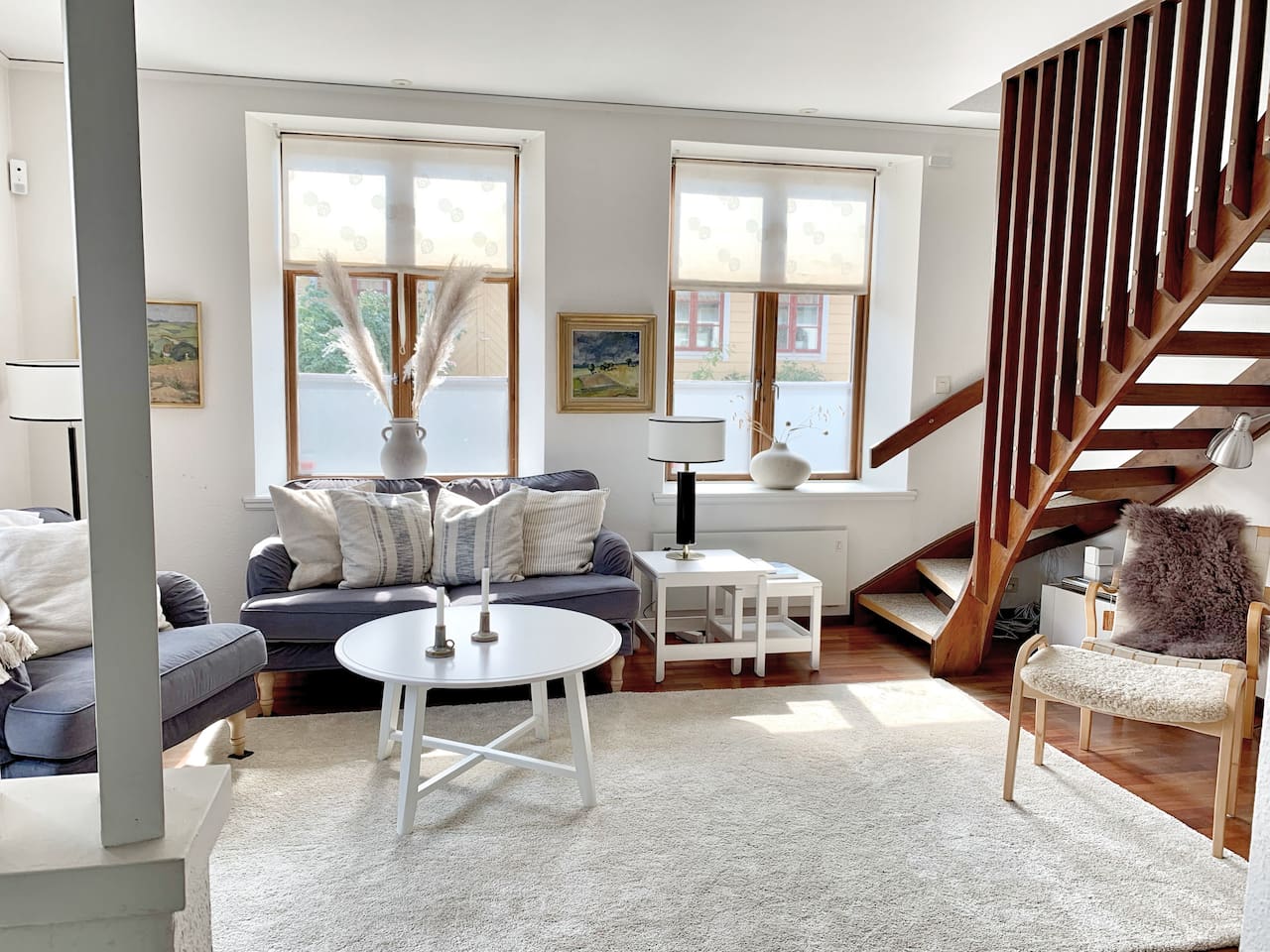 Vardagsrum med soffgrupp, tv och altandörr ut till trädgården. 