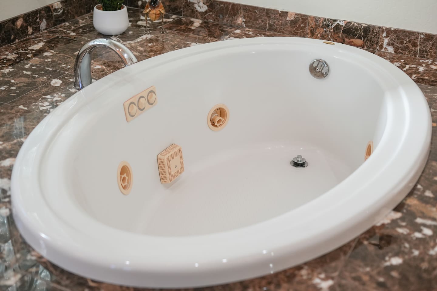 Close-up of the soaking tub with spa-style jets and modern fixtures.