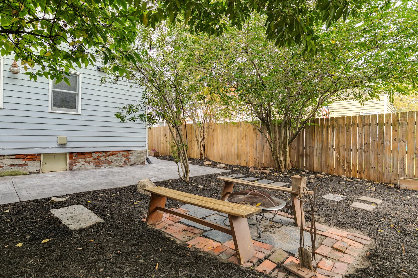 Backyard Oasis: Gather around the fire pit under lush trees and enjoy evening conversations!