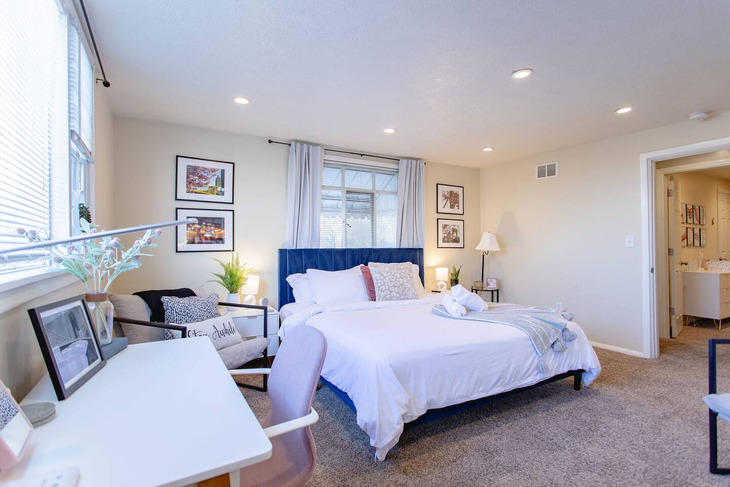 Cozy, spacious room with a queen-sized bed, TV, and a dedicated working space.