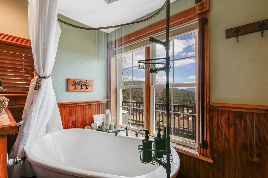 Soaker tub and rainfall showerhead in the main bathroom. A relaxing spot to unwind.