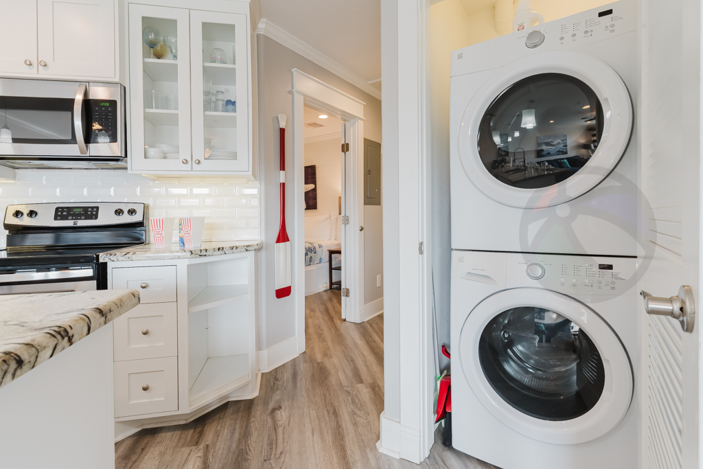There are full sized laundry appliances in a closet across from the kitchen