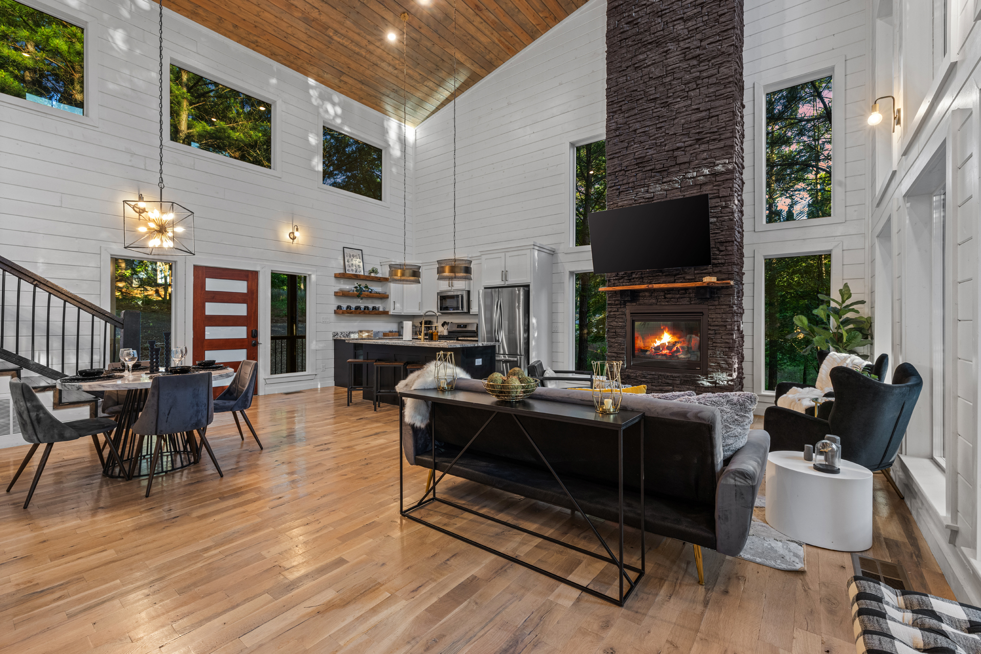 A warm and spacious living area designed for gathering and unwinding — featuring plush seating, cozy accent chairs, a stunning fireplace, and a large TV perfect for movie nights after a day of adventure. ✨