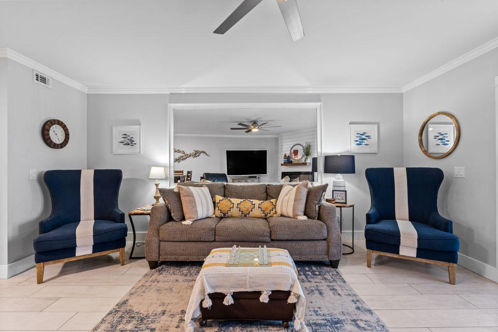 Spacious living area with fireplace, ceiling fan and smart TV