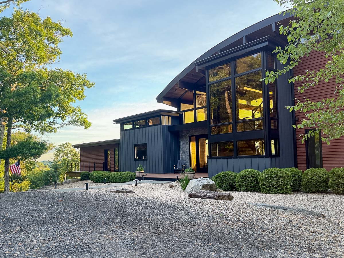 Front of Sunset Falls Estate at an angle, sunlight held in the windows &mdash; Berkshires modern mountain home