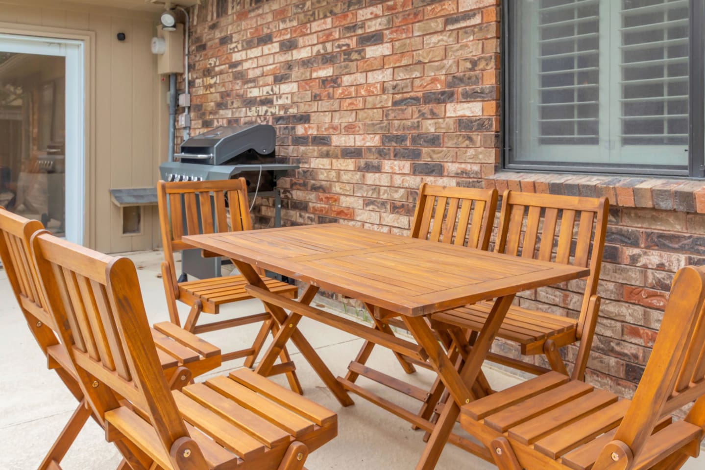 Sunny outdoor dining area beside the private pool, complete with outdoor furniture and fully fenced garden for privacy.
