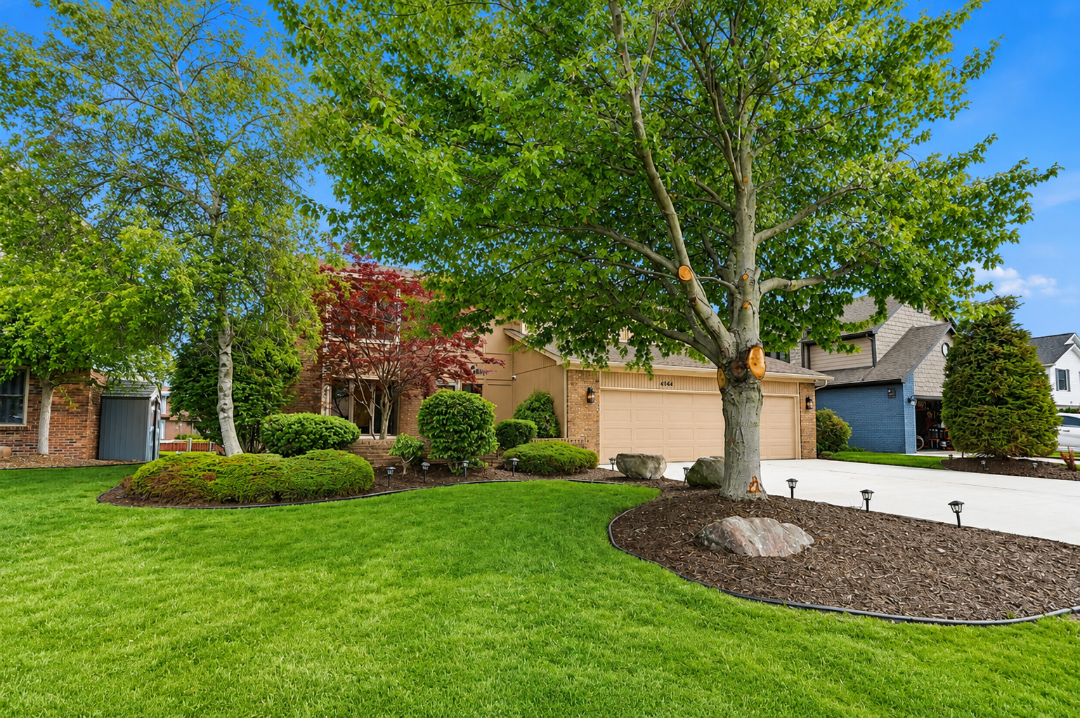 XX Spacious front yard with mature trees, manicured lawn, and a quiet suburban setting. Well-maintained curb appeal in a peaceful residential neighborhood.