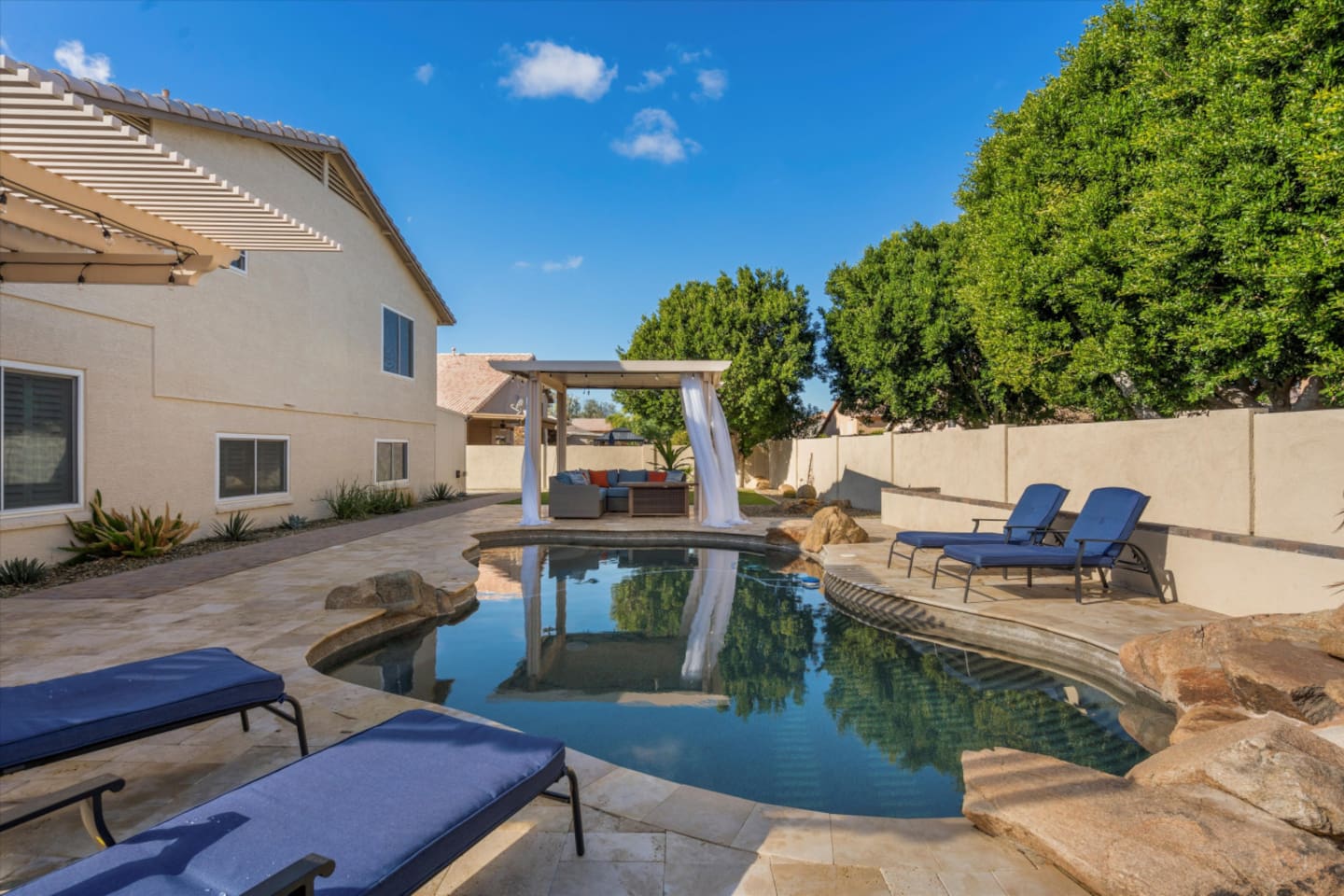 Backyard pool with lounge chairs, shaded seating, and a quiet spot to relax outside.
