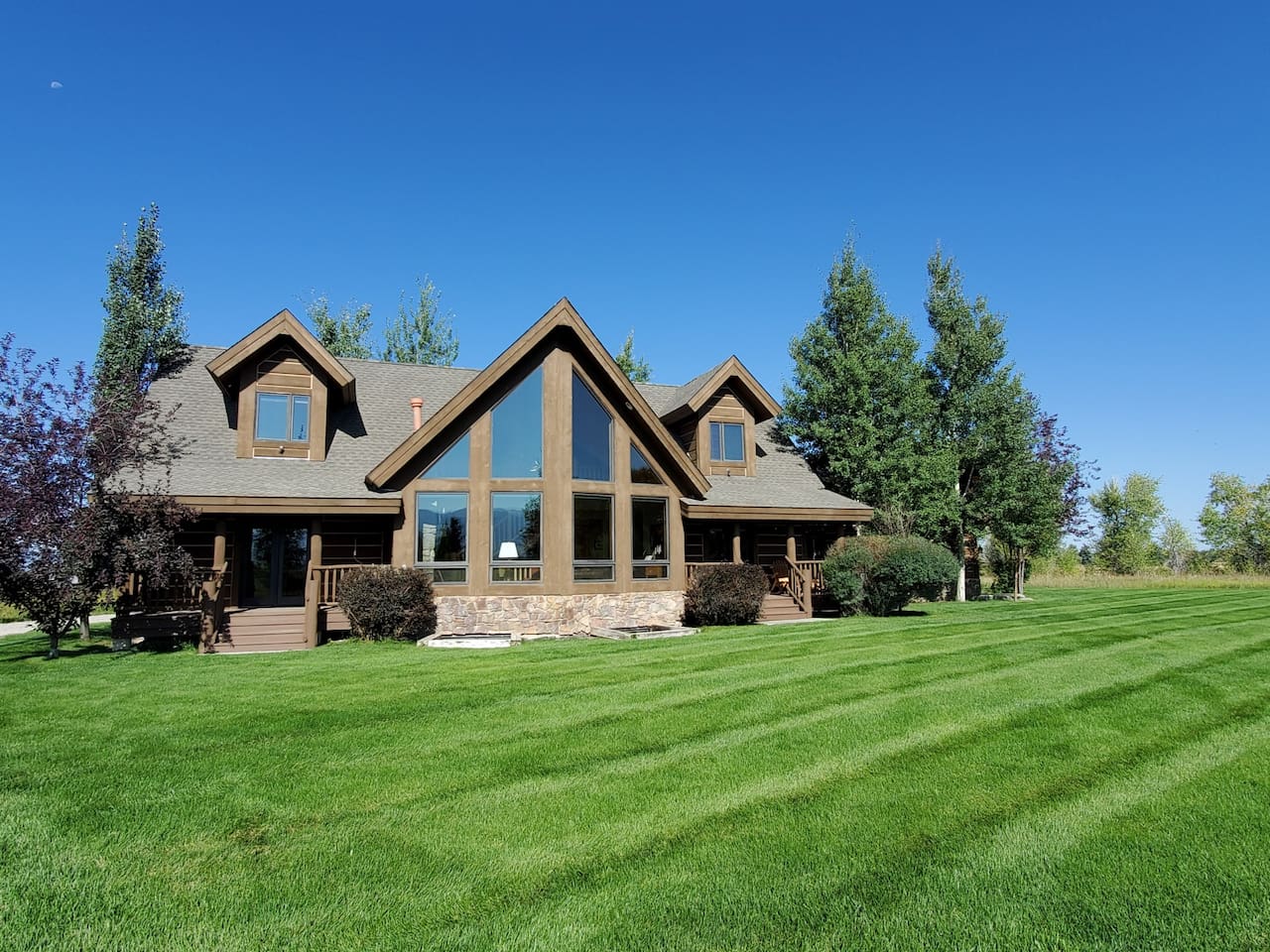 Soak in the beauty of this stunning A‑frame retreat, set on expansive, manicured grounds and surrounded by open space. The home’s striking architecture and dramatic windows create a warm, inviting space to relax and enjoy the peaceful setting.