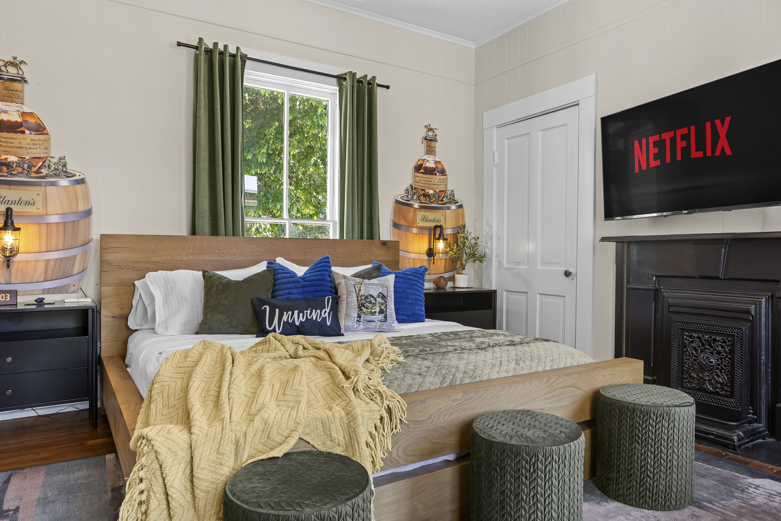 Every corner of the Blanton's Room is styled with intention. Barrel nightstands, green velvet curtains, and warm bourbon art.