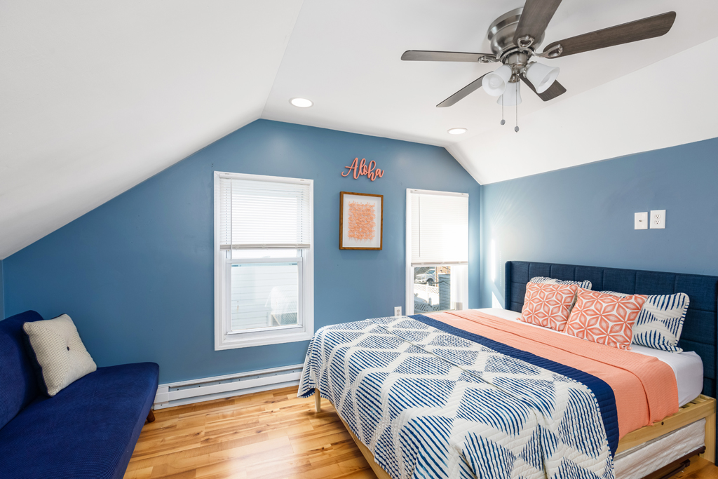 Drift off in this coastal second floor primary bedroom of the cottage.