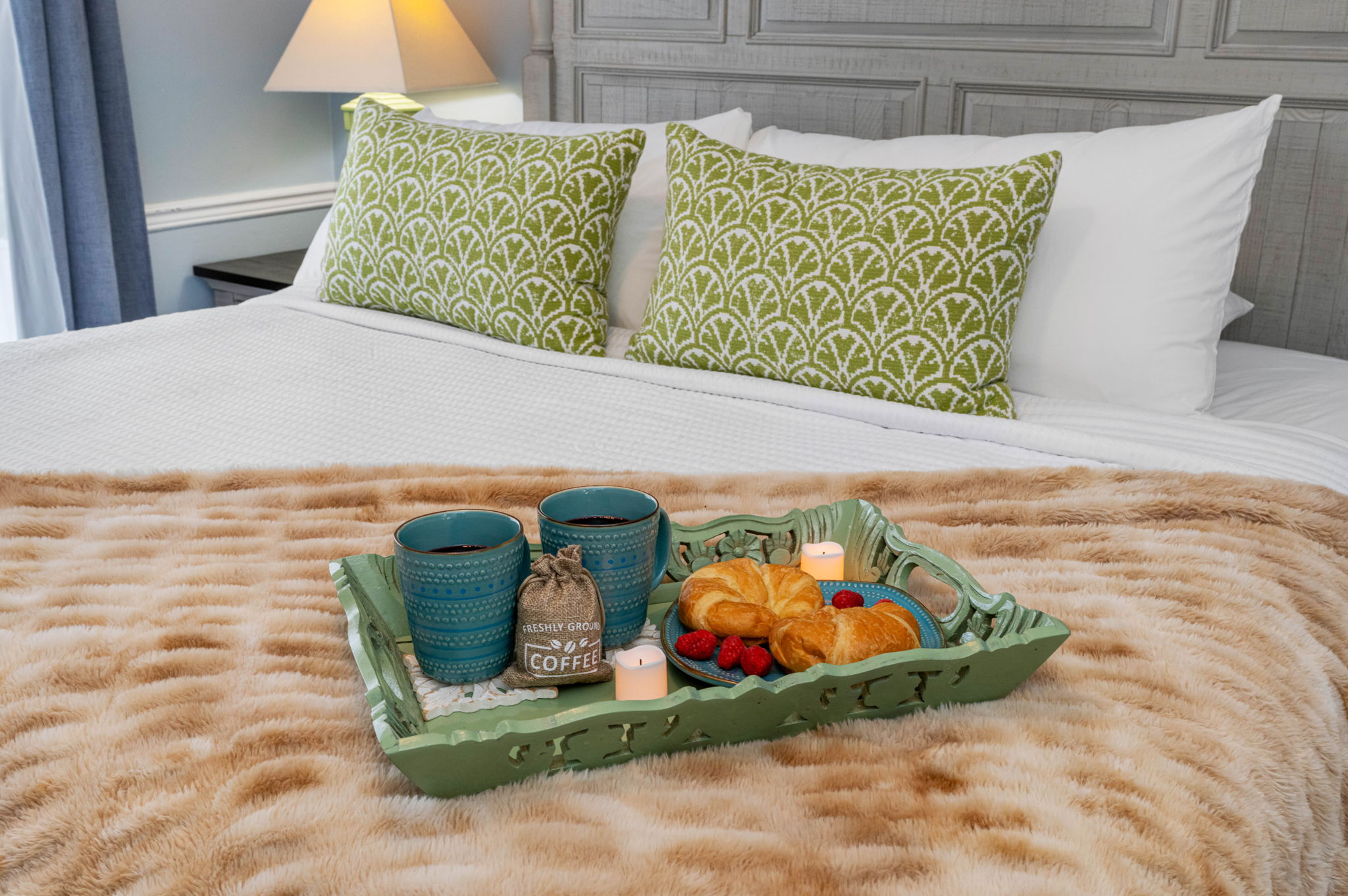 Featuring a sumptuous king-size bed with a detailed wood-paneled headboard and coordinating bedside tables.